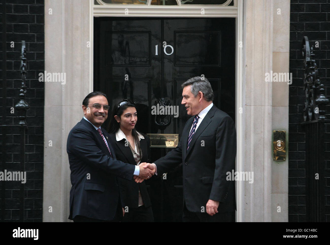 Premierminister Gordon Brown schüttelt sich die Hände mit dem pakistanischen Präsidenten Asif Ali Zardari, während seine Tochter Asifa Bhutto Zardari in der Downing Street 10 in London zuschaut. Stockfoto