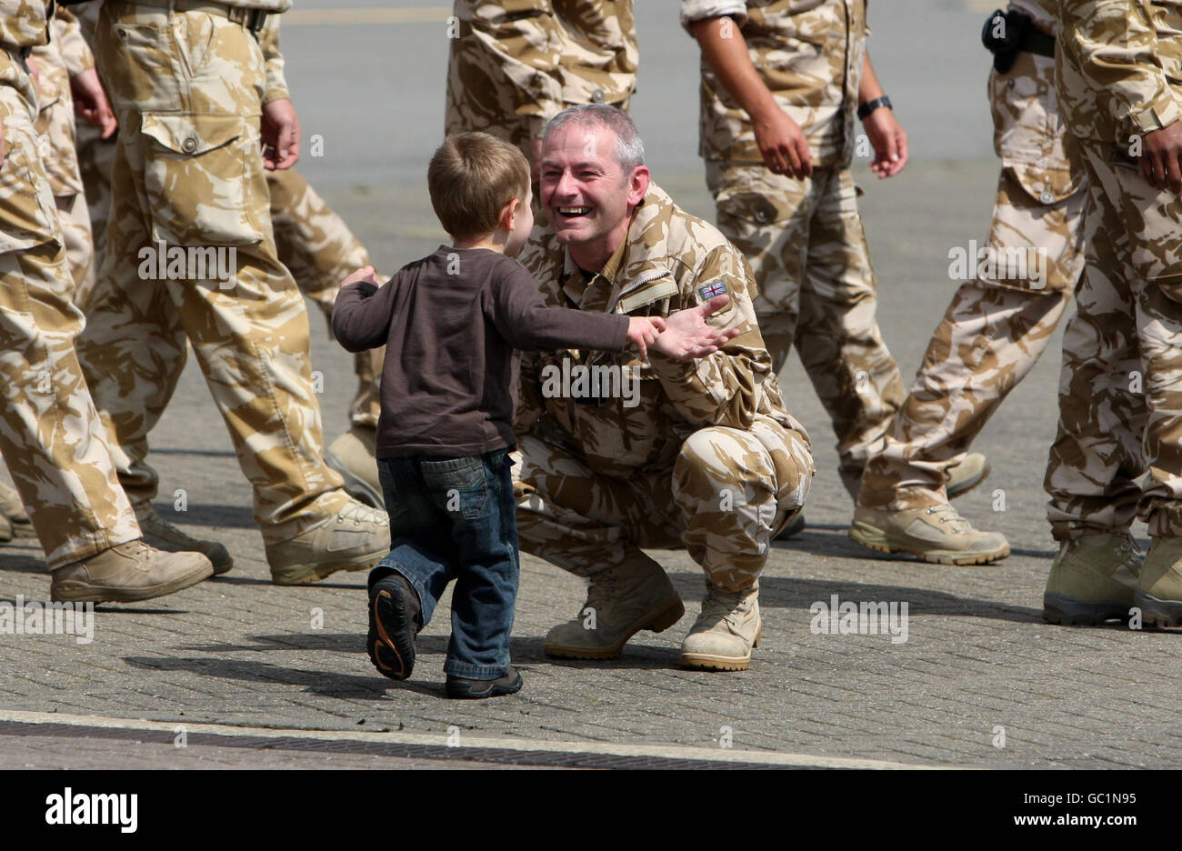 CPL Damian Duffy wird von Sohn Oliver begrüßt, als die letzten beiden Merlin-Hubschrauber vom Irak nach RAF Benson in Oxfordshire zurückkehren. Stockfoto