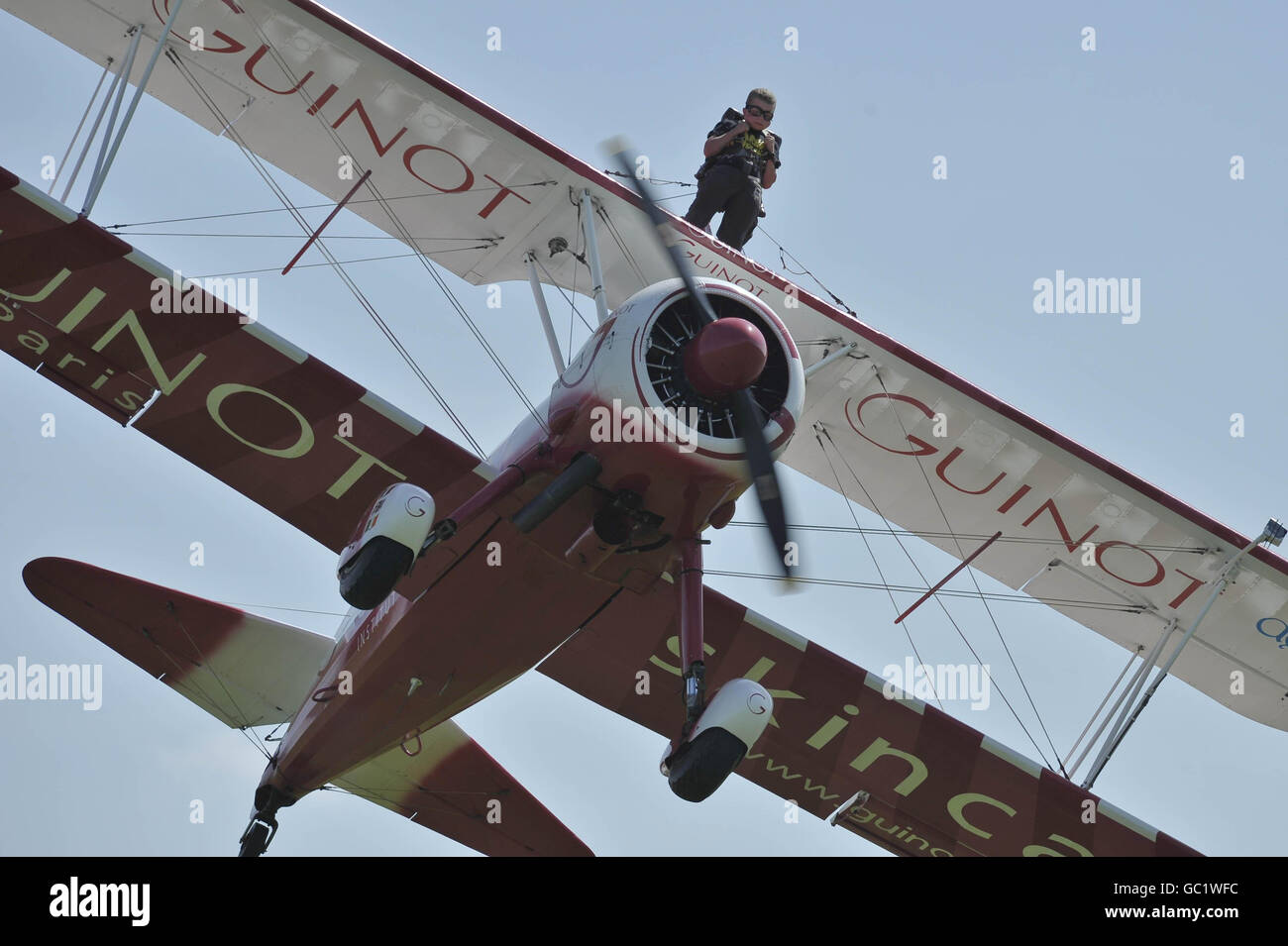 Der achtjährige Tiger Brewer wingwalks auf dem Doppeldecker seines Großvaters und in die Rekordbücher, als er der jüngste Wingwalker der Welt auf dem RFC Rendcomb Airfield in der Nähe von Cirencester wurde. Stockfoto