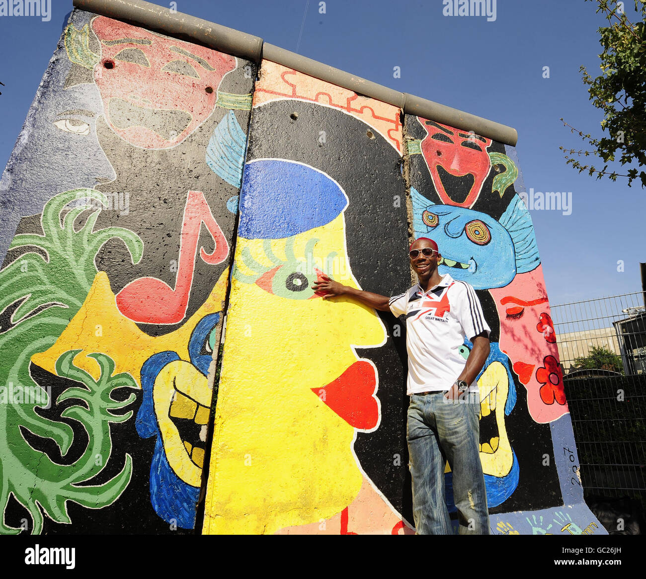 Der britische Phillips Idowu posiert vor der Berliner Mauer für die Medien, nachdem er während der IAAF-Weltmeisterschaft im Olympiastadion in Berlin eine Pressekonferenz auf einem Open-Air-Tourbus hielt. Stockfoto