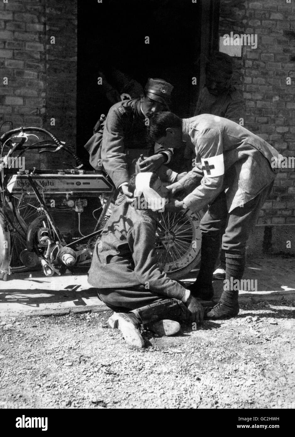 Ein verletzte Soldat wird von medizinischen Anorderlies der französischen Armee gepflegt. Das Motorrad an der Wand ist ein britisch gemachtes 1914 Rudge Multi. Stockfoto