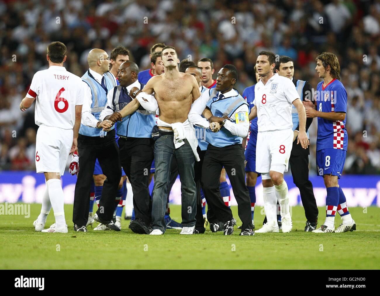 Stewards versuchen, einen koatianischen Unterstützer vom Feld zu entfernen Spielen, nachdem er rennt auf seine Seite zu feiern Treffer gegen England Stockfoto