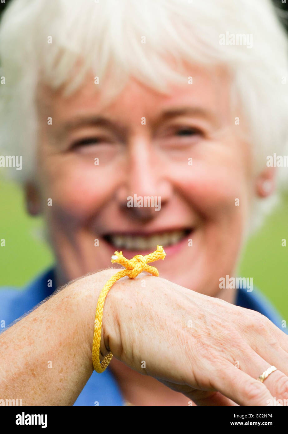 Die TV-Persönlichkeit und Ex-Rechtsanwältin Margaret Mountford knüpft einen „Forget Me Knot“ an, um ihre Unterstützung für Charity-Konsortien „Remember A Charity's Forget Me Knot Week“ zu zeigen. Stockfoto