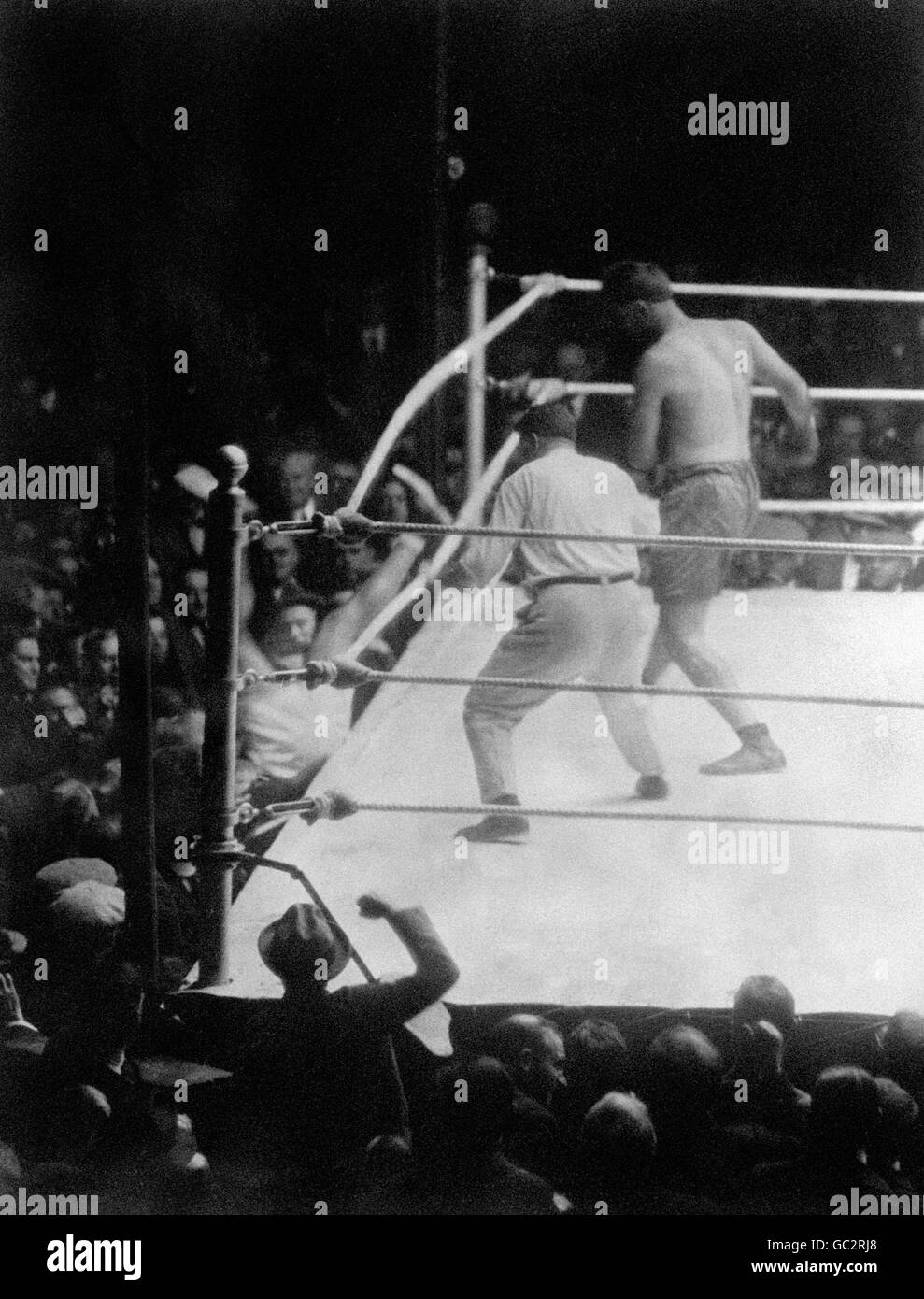 Luis Firpo klopft Jack Dempsey durch die Seile in die Presserreihe, wo er auf einer Reporter &#8217;s Schreibmaschine landete. Dempsey kam wieder in den Ring und stoppte Firpo mit zwei Rückschlägen in der zweiten Runde. Stockfoto