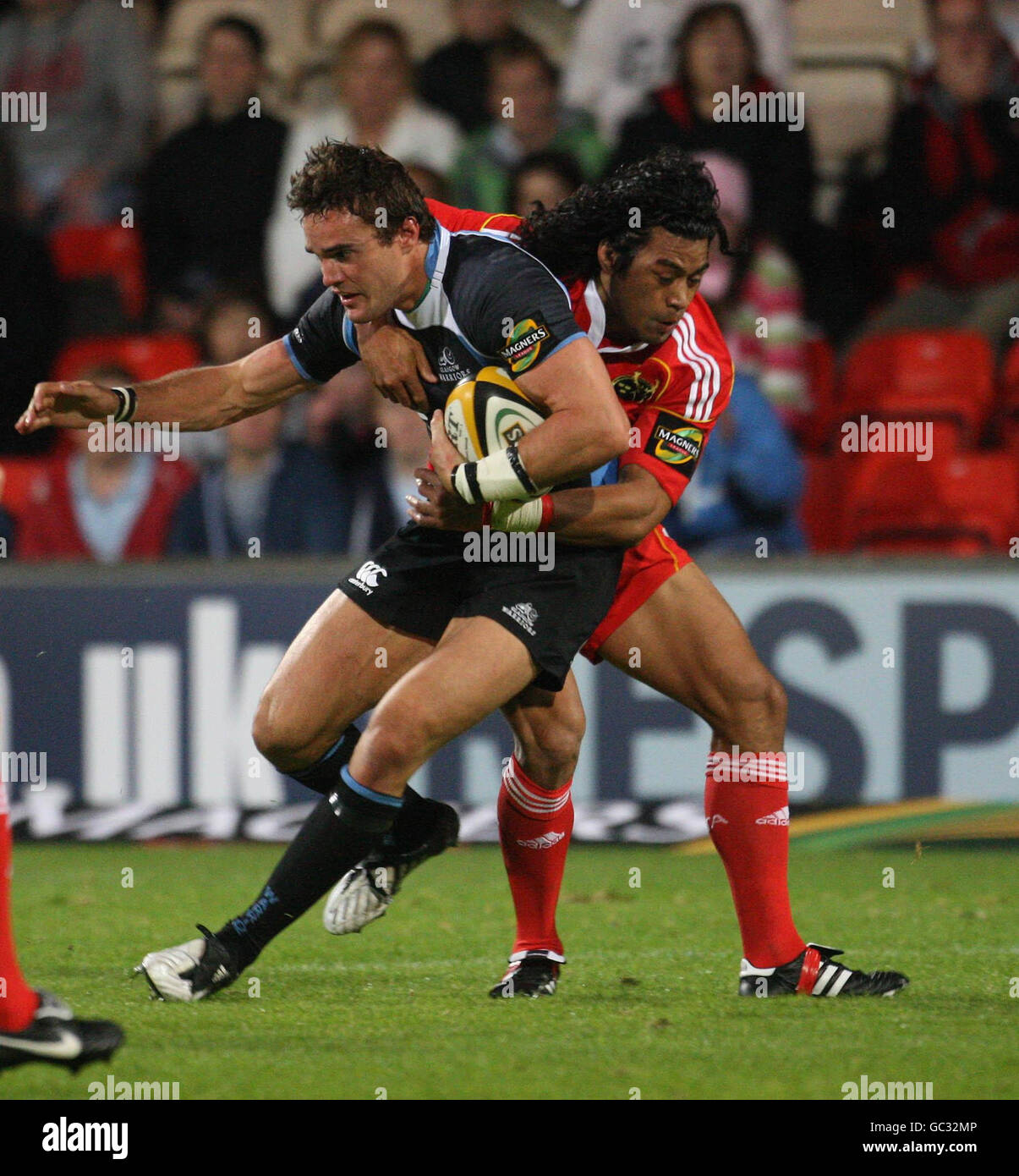 Thom Evans von Glasgow Warriors wird von Munsters Lifeimi Mafi (hinten) während des Spiels der Magners League im Firhill Stadium in Glasgow angehalten. Stockfoto