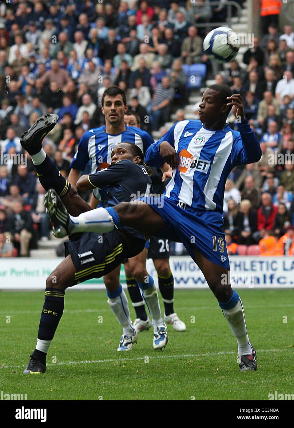 Fußball - Barclays Premier League - Wigan Athletic gegen Chelsea - DW Stadium. Chelseas Didier Drogba (links) versucht ashot auf das Tor hinter Titus Bramble von Wigan Athletic Stockfoto