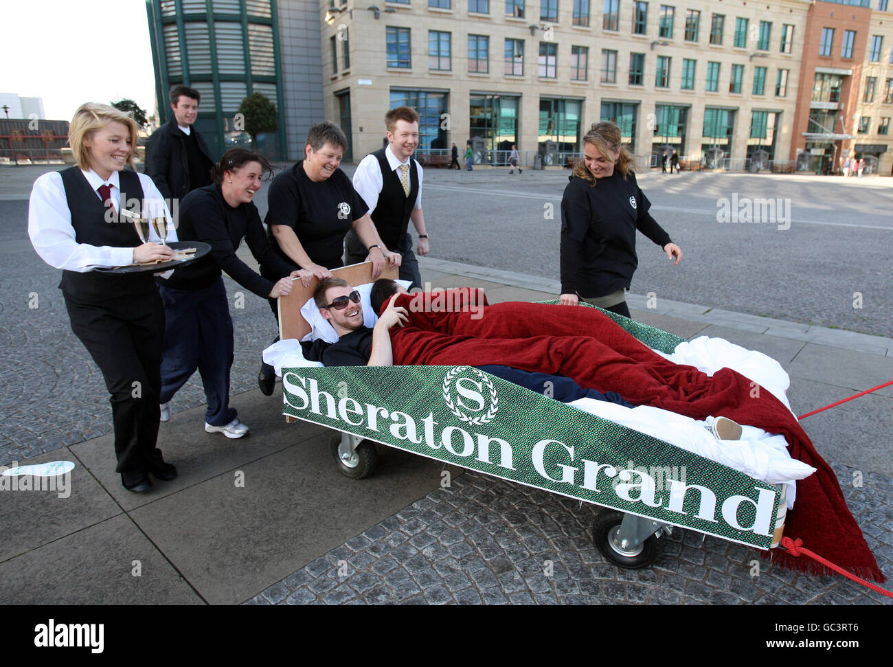Miles for Smiles - 500 Meilen. Ein Paar in einem Bett wird eine Meile durch Edinburgh gezogen, für die Miles for Smiles Veranstaltung. Stockfoto