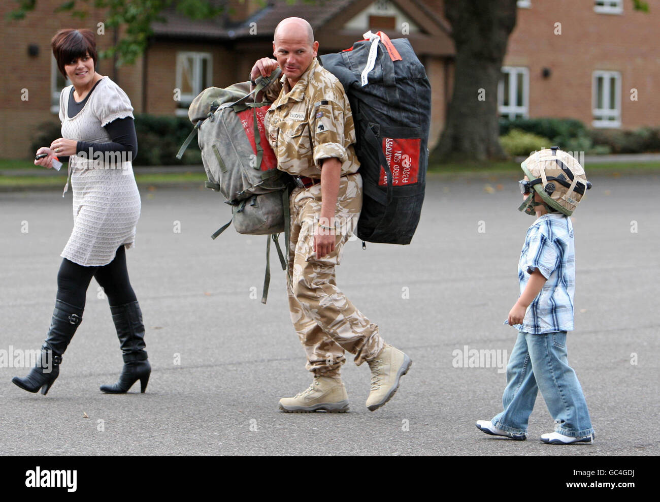 Stabsfeldwebel Kevin Vaughan wird von seiner Frau Christie und seinem Sohn Owen begrüßt, als 75 Royal Engineer und Royal Logistic Corps nach sechs Monaten in Afghanistan Bombenentsorgungs- und Suchspezialisten nach Carver Barracks, Wimbish, Essex zurückkehren. Stockfoto