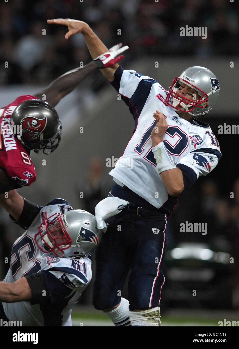 Tom Brady (rechts) der New England Patriots geht während des NFL-Spiels im Wembley Stadium, London, unter Druck von Jimmy Wilkerson von Tampa Bay Buccaneers (links) vorbei. Stockfoto