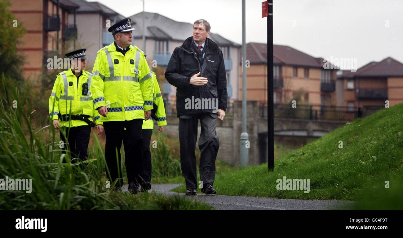 Justizminister Kenny MacAskill (rechts) geht mit dem Hauptkommissar Paul Bullen während eines Besuchs in Wester Hailes in Edinburgh nach der Veröffentlichung der Scottish Crime & Justice Survey 2008/2009. Stockfoto