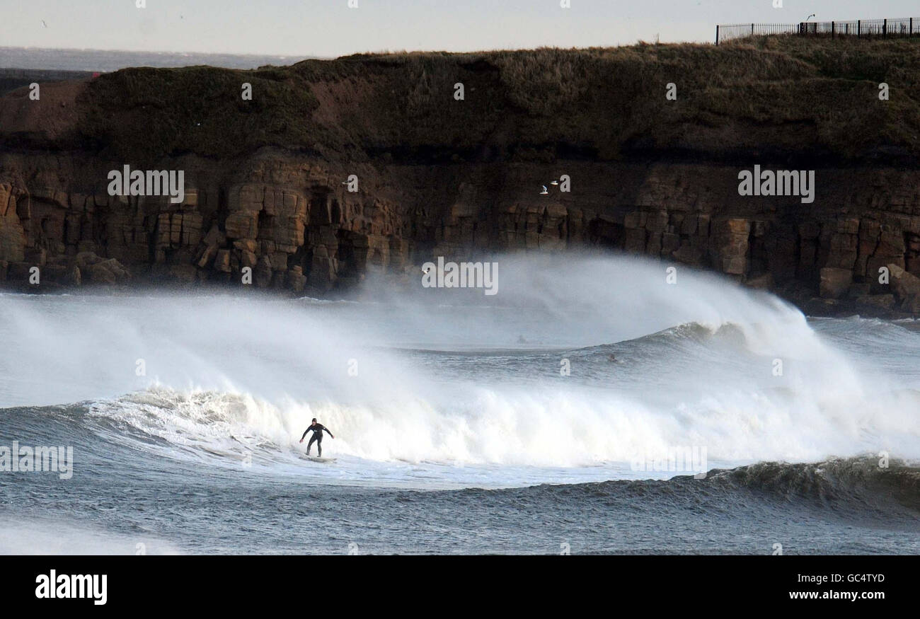 Ein Surfer genießt die Brandung in Tynemouth, North Tyneside, Tyne und Wear, wie schwere Regengüsse und starke Winde, die viel von Großbritannien getroffen. Stockfoto