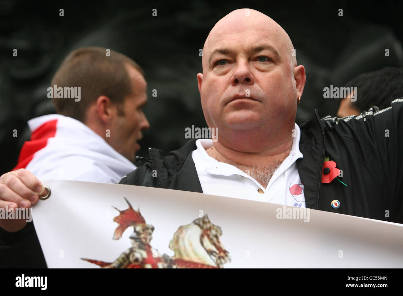 Ein Mann, der sich einem muslimischen Prediger widersetzt, der heute in London predigen sollte, stellt sich heraus, um seine Opposition durch die Eros-Statue, Piccadilly Circus im Zentrum Londons, zu zeigen. Stockfoto