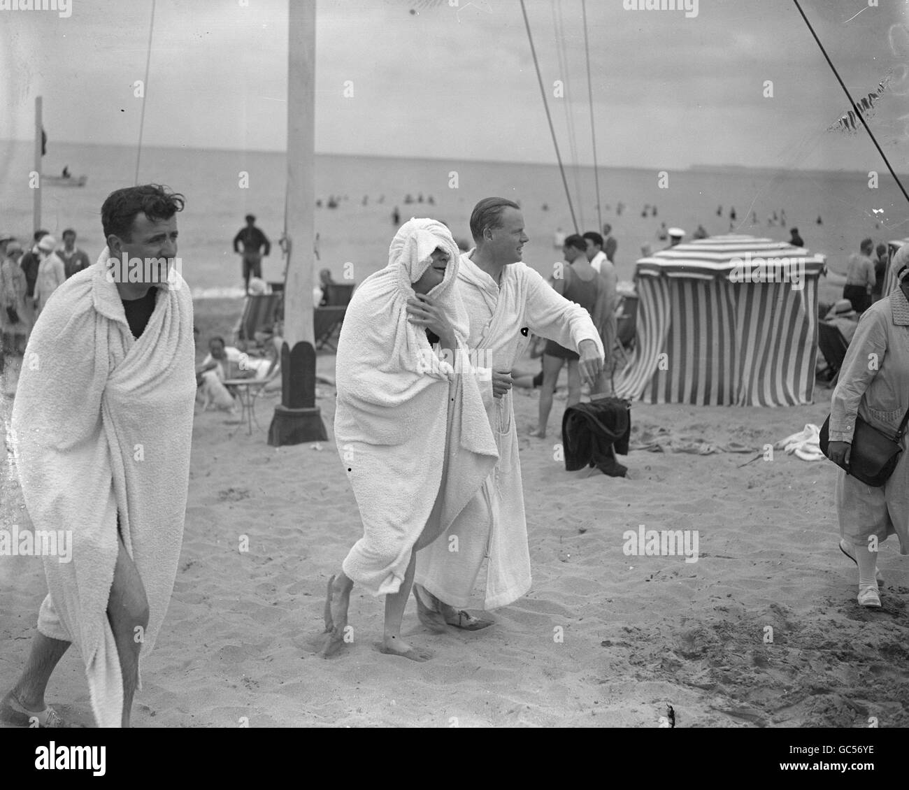 Schatzkanzler Winston Churchill und Herzog von Sutherland verkrümmen sich in Handtüchern, nachdem sie ein Bad genommen haben Das Meer Stockfoto