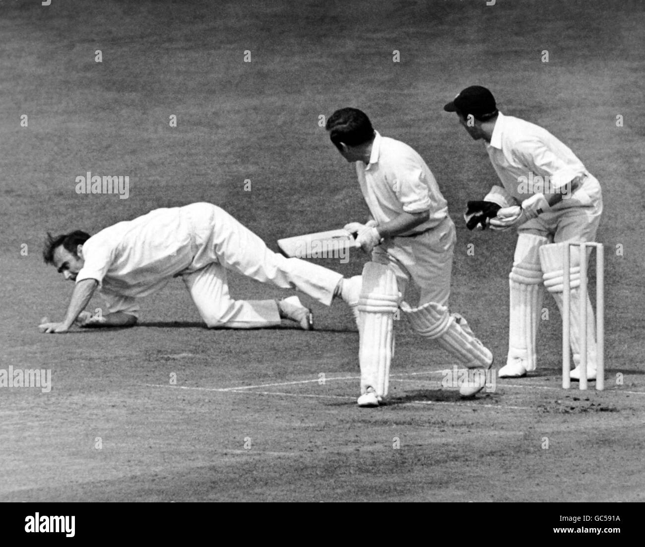 K. G. SUTTLE (Sussex) spielt einen Ball von F.J. TITMUS (Middlesex) als R.W.HOOKER (Middlesex) taucht, um zu fangen, aber verfehlt. Stockfoto