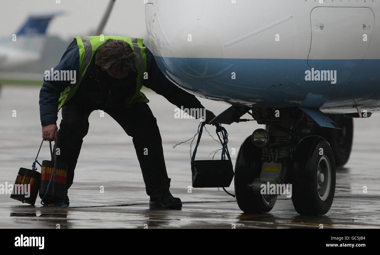 Ein Mitarbeiter des Flughafens kümmert sich um ein Flugzeug, das an seinem Gate am Flughafen Manchester ankommt. Stockfoto
