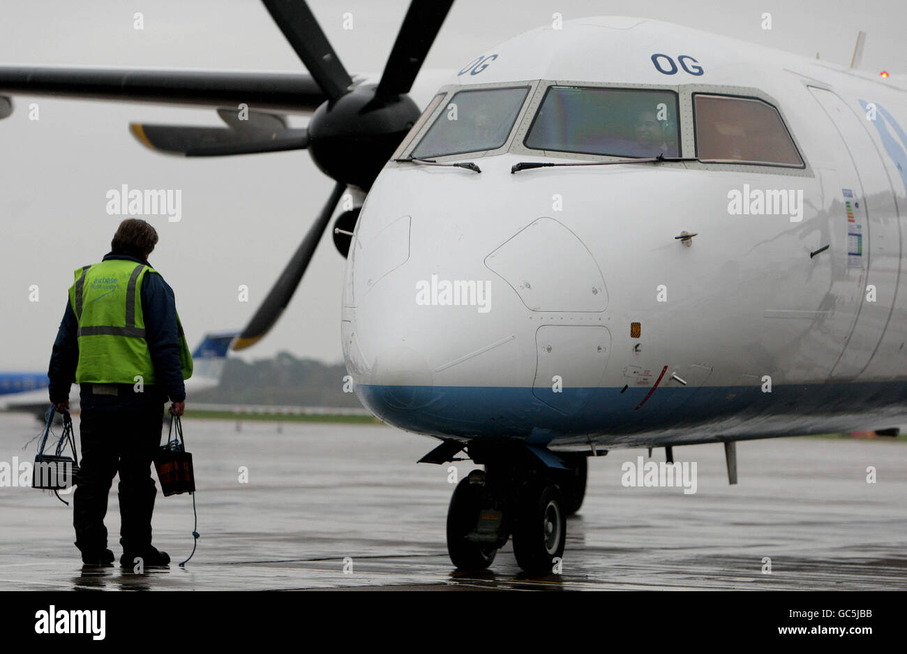 Ein Flughafenmitarbeiter wartet auf ein Flugzeug, das am Flughafen Manchester ankommt. Stockfoto
