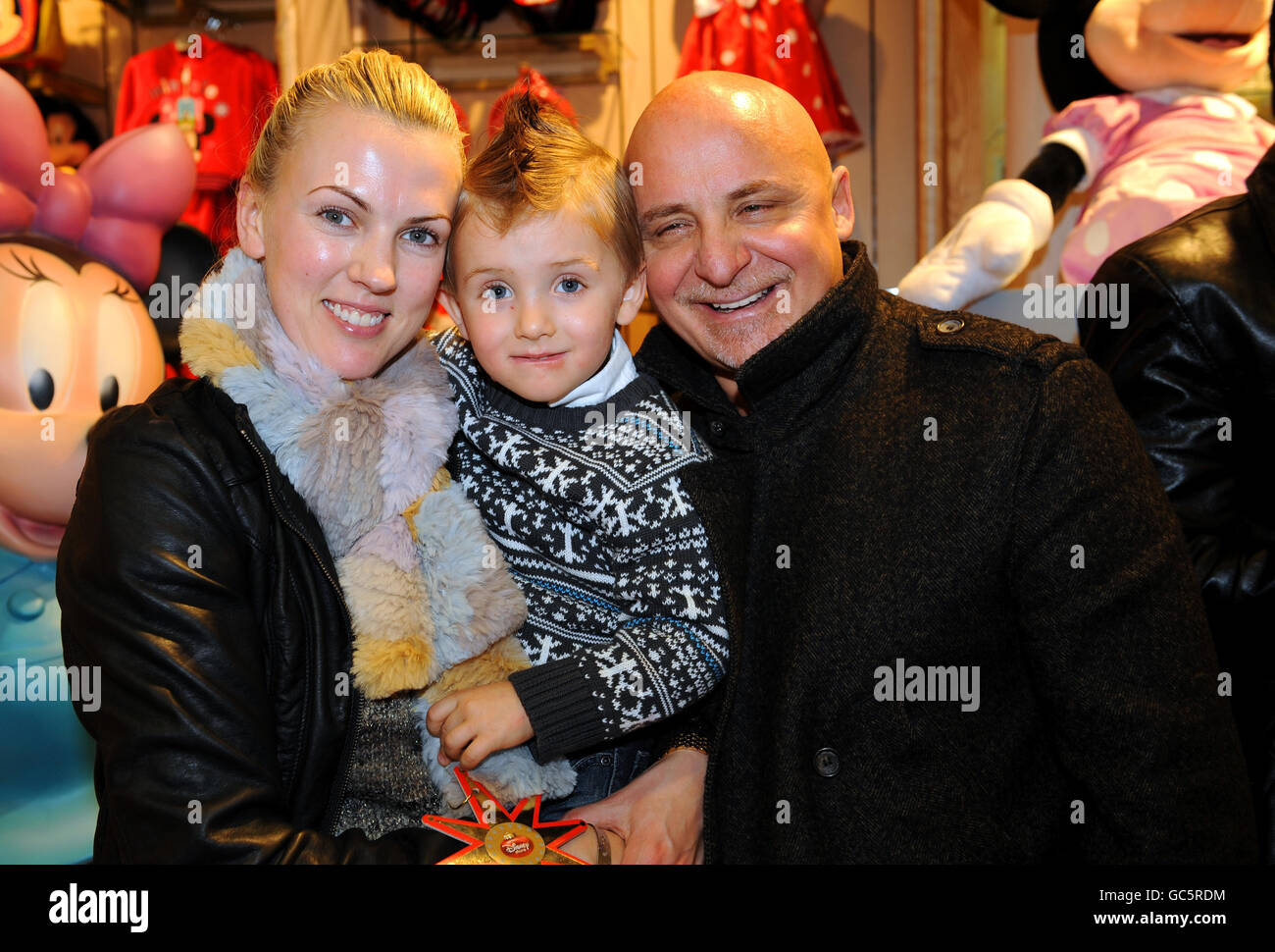 Küchenchef Aldo Zilli, seine Frau Nikki und sein Sohn Rocco, die sich Patienten des Great Ormond Street Hospital im Disney-Geschäft in der Oxford Street, London, anschlossen, wo die Marke ihre Weihnachtskollektion lancierte. Stockfoto
