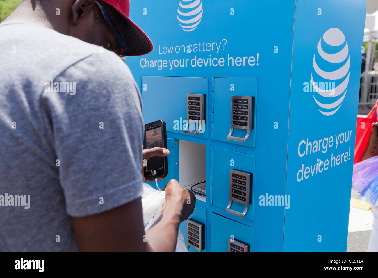 Junger Mann mit einer AT&T mobile Ladestation - USA Stockfoto