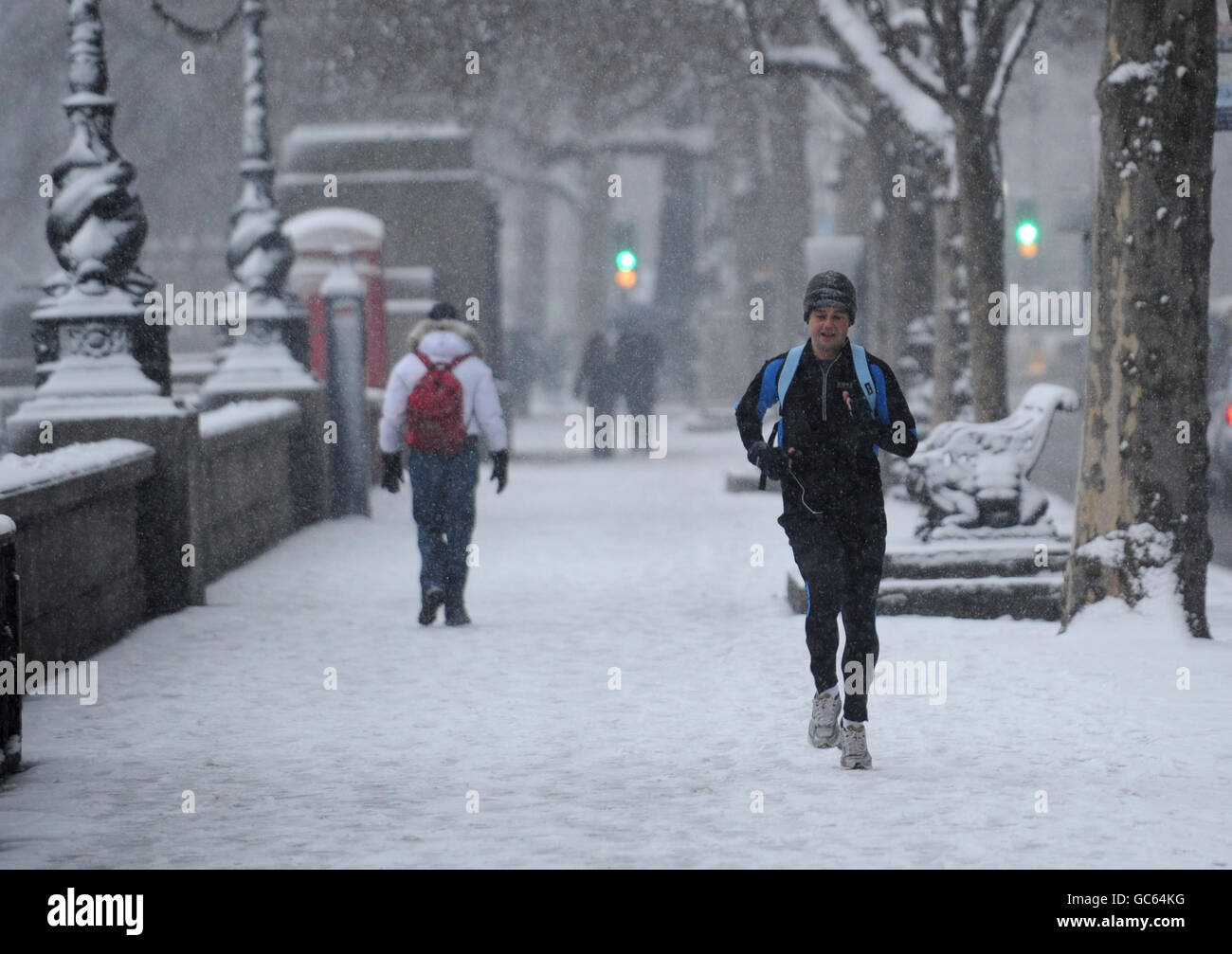 Pendler auf dem Embankment in London heute Morgen tapferen Schneesturm Bedingungen auf dem Weg zur Arbeit. Stockfoto