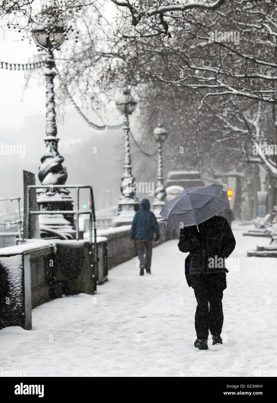 Pendler auf dem Embankment in London heute Morgen tapferen Schneesturm Bedingungen auf dem Weg zur Arbeit. Stockfoto