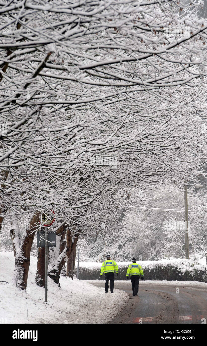 Polizisten machen ihren Weg zu Fuß in Usk, nachdem Teile von Großbritannien von einer neuen Schneewelle getroffen wurden. Stockfoto
