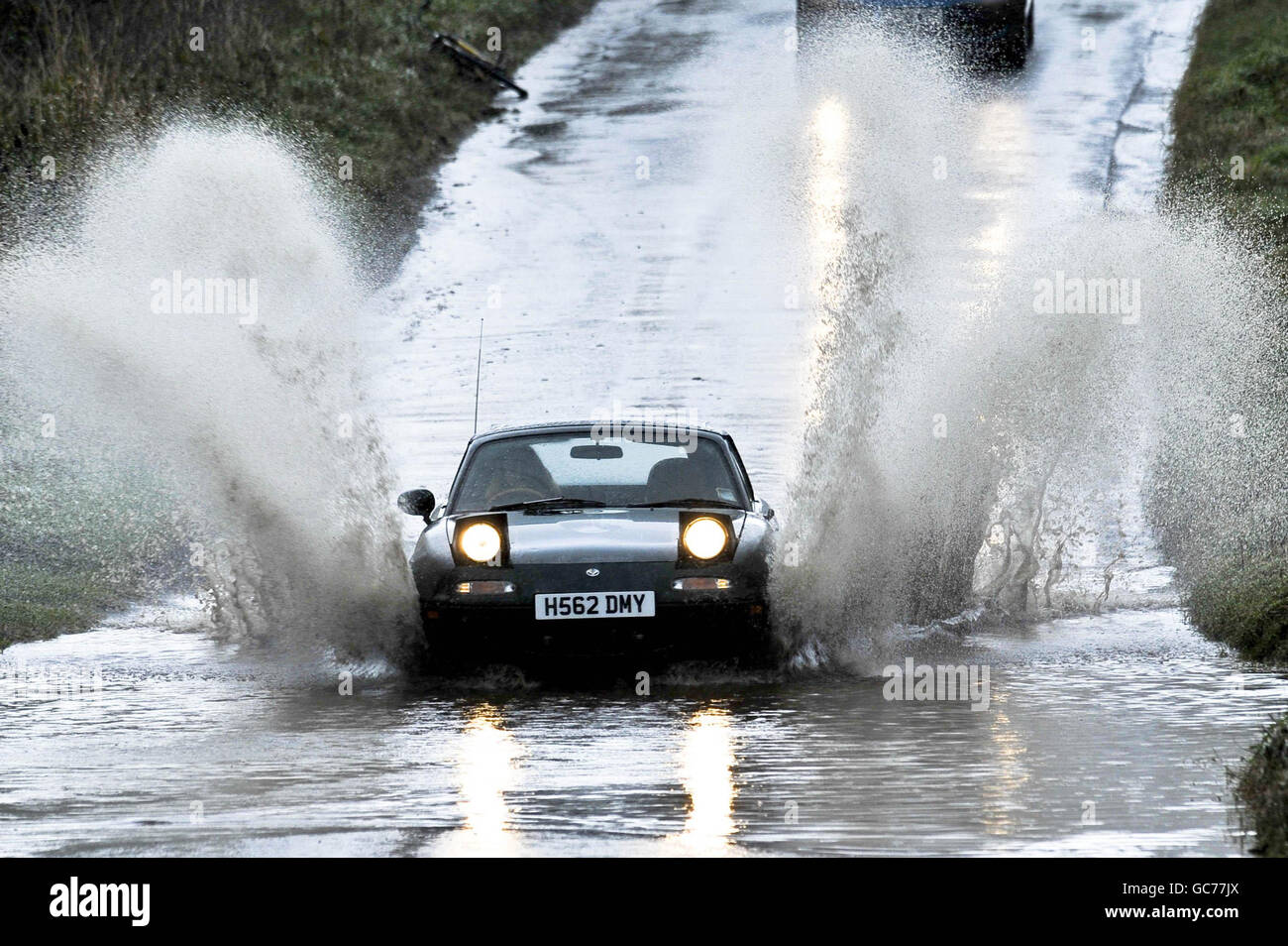 Nach zwei Tagen starken Regens bahnt sich ein Auto seinen Weg durch eine überflutete Straße in Somerset. Die Straßen des Landkreises haben weit verbreitet stehendes Wasser und lokalisierte überflutete Gebiete nach dem, was einer der nasseste November auf Rekord gewesen. Stockfoto