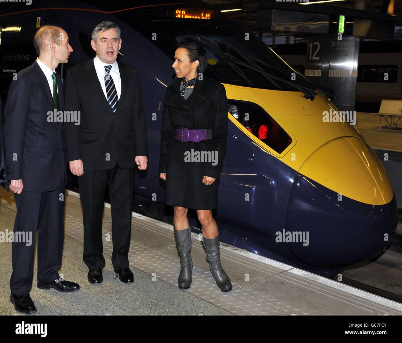 Premierminister Gordon Brown (Mitte) wird am ersten Tag der neuen Hochgeschwindigkeitszüge des Javelin-Zuges von Verkehrsminister Lord Adonis (links) und Dame Kelly Holmes (rechts) am Bahnhof St. Pancras in London begleitet. Stockfoto