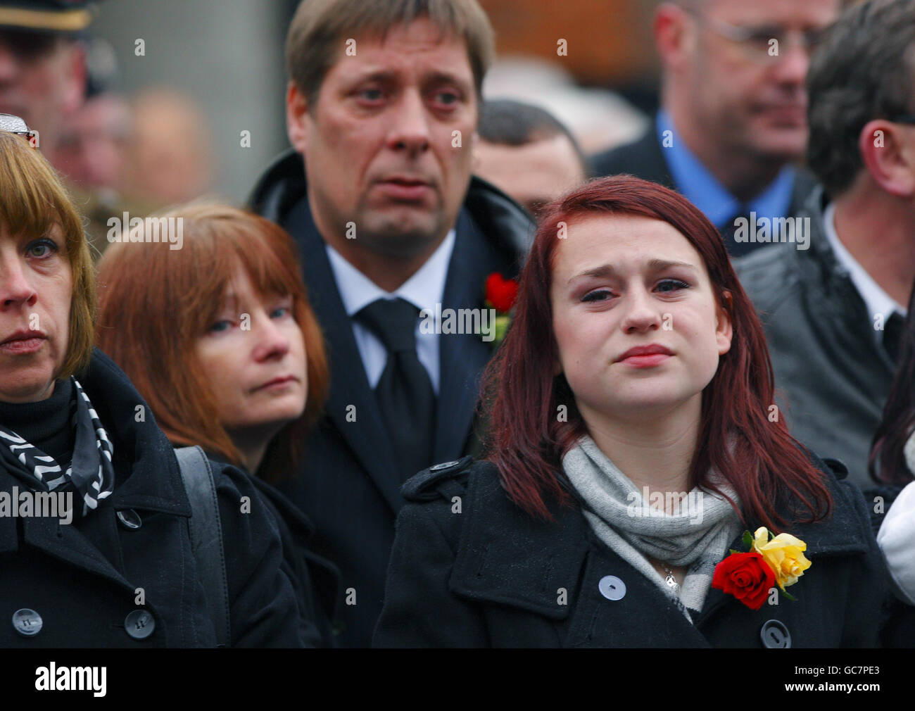 Sian Goodenough, der Verlobte von Lance Corporal Adam Drane wartet mit seinen Eltern des und Jackie (hinten) auf seinen Sarg, der durch Wootton Bassett in Wiltshire führt. Stockfoto