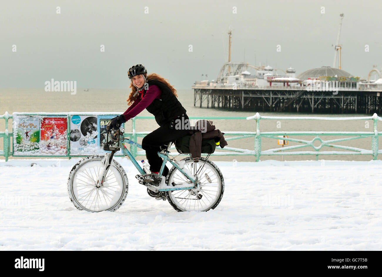 Angela Roy radelt zur Arbeit entlang der schneebedeckten Strandpromenade in Brighton. Stockfoto