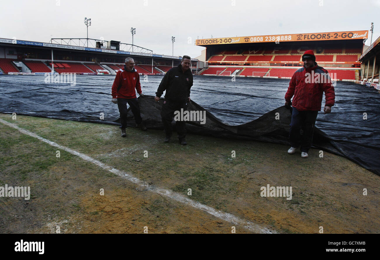Bodenpersonal deckt den gefrorenen Eckflaggenbereich des Platzes ab, der bedeutete, dass der Schiedsrichter das Spiel gegen Norwich City kurzfristig vor dem Coca-Cola League One Spiel im Banks's Stadium, Walsall, abrief. Stockfoto