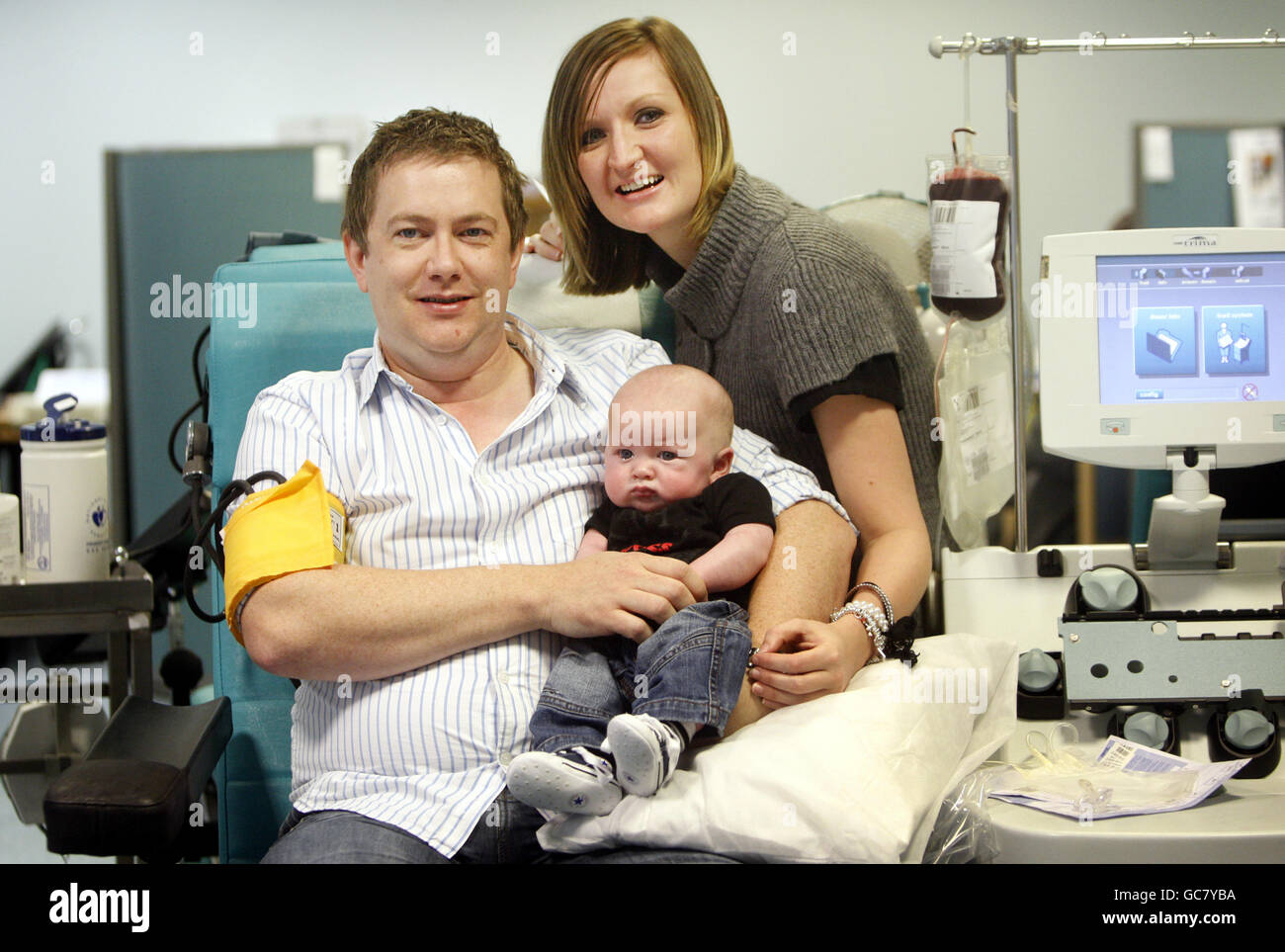 John und Julieann Carr mit Sohn Charlie Carr, während eines Besuchs in einem Scottish National Blood Transfusion Service Blutspendezentrum in Glasgow. Charlie brauchte Blut-, Plasma- und Thrombozytenspenden, als er sich von einer neunstündigen Operation erholte, um einen Tumor von seiner Wirbelsäule und seinem Bauch zu entfernen. Stockfoto