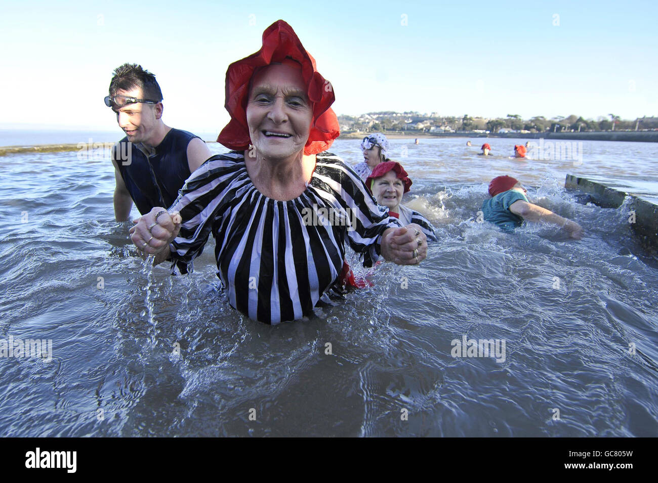 Joyce Peters, 78, aus Clevedon, kommt mit anderen Schwimmern in viktorianischen Badekostümen zusammen, während sie am Neujahrstag in der Marina von Clevedon schwimmen, wo die Temperatur nur knapp über dem Gefrierpunkt liegt. Stockfoto