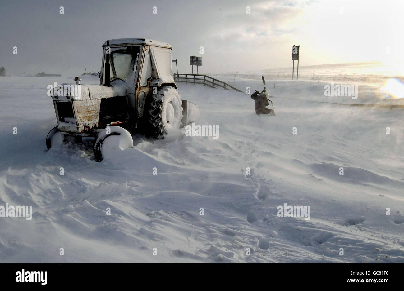 Ein Landwirt und sein Traktor in Denshaw bei Oldham, da in den meisten Teilen Großbritanniens weiterhin starker Schneefall besteht. Stockfoto