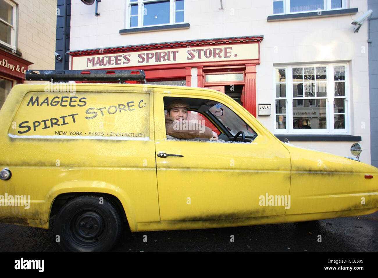 Der fantasievolle Publizist Mark 'del Boy' Drumm, 28, mit seinem neuen Lieferwagen - einem gelben dreirädrigen Reliant Regal vor dem Magee's Spirit Store in Enniskillen, Nordirland. Stockfoto