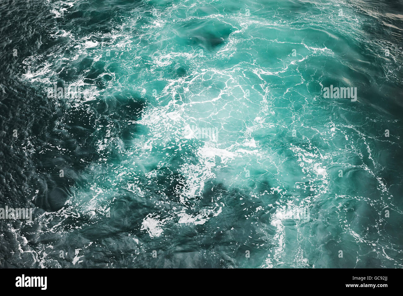 Stürmisches Meer Wasser Oberfläche mit weißem Schaum und Wellen-Muster, Foto Hintergrundtextur Stockfoto