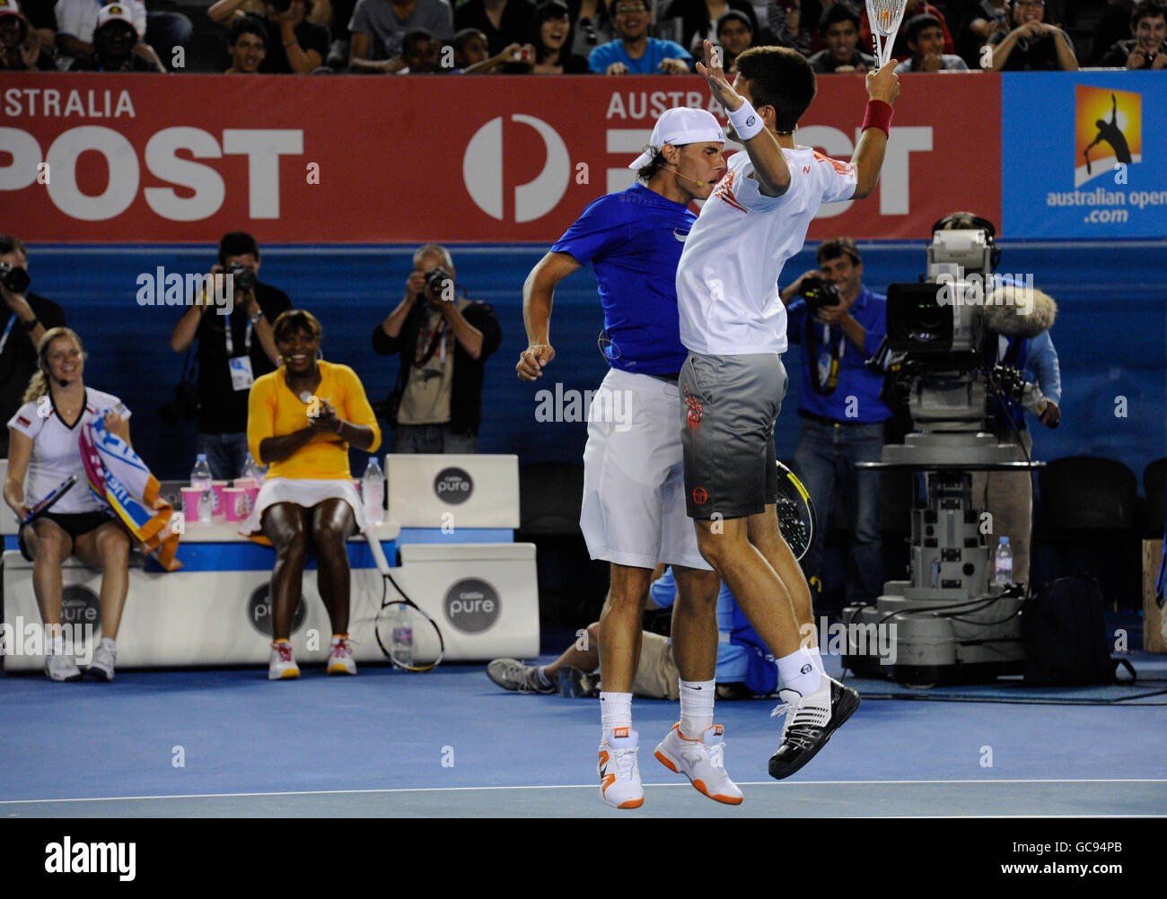 Tennis - Australian Open 2010 - Trainingstag - Melbourne Park. Rafael Nadal und Novak Djokovic stoßen während der Spendenaktion zur Unterstützung Haitis nach dem Erdbeben Truhen auf Stockfoto