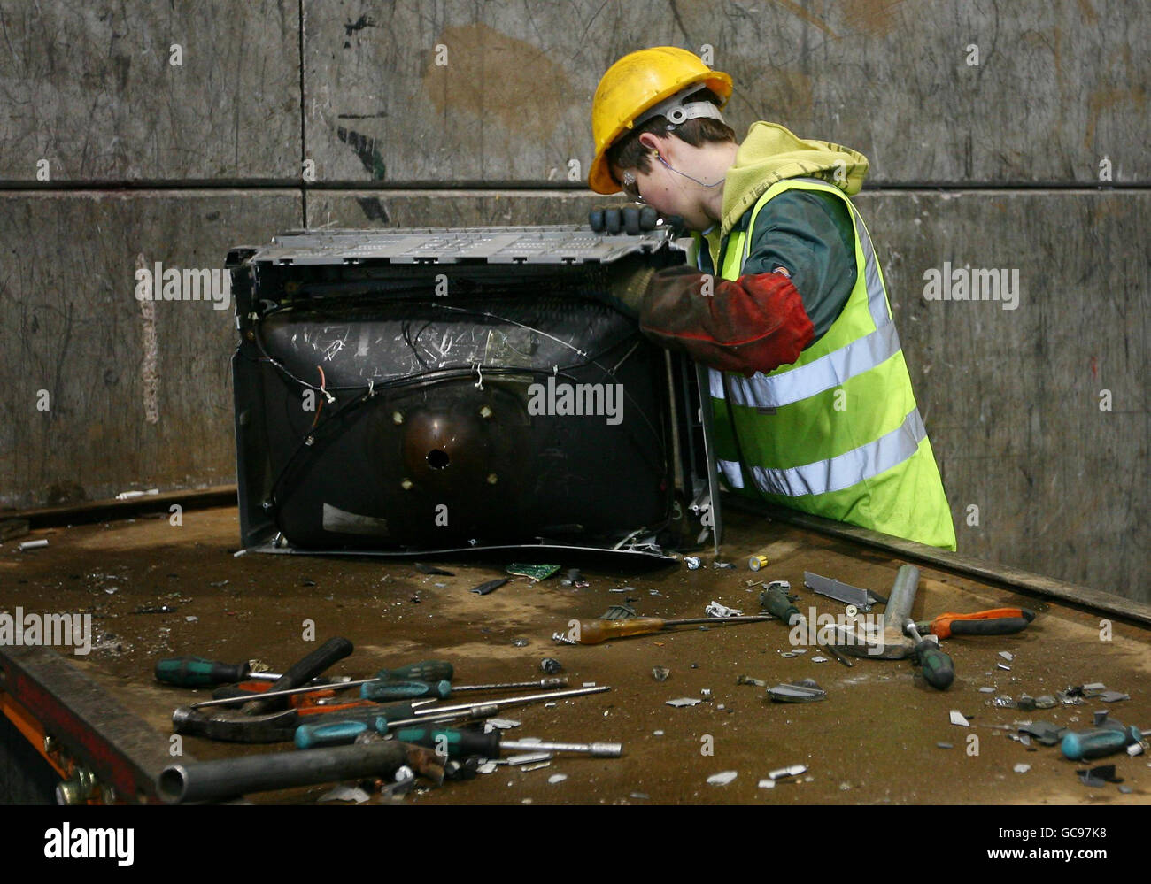 Alte Fernseher und Computermonitore werden in der ersten Verarbeitungsstufe bei der Recyclingfirma SWEEEP in Sittingbourne, Kent, per Hand in ihre Hauptkomponenten zerlegt, da die Nachfrage nach Flachbildschirmen das Unternehmen derzeit 4,000 der alten oder defekten Bildschirme alle 24 Stunden recycelt. Stockfoto