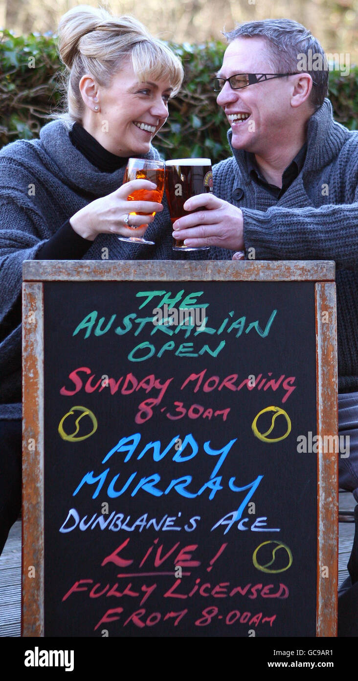 Tommy Smith und Margaret Nelson stoßen im Dunblane Hotel neben einem Schild an, auf dem die Hotel Special Drinks License in der Dunblane High Street steht, während die Stadt ihre Unterstützung für den lokalen Tennisspieler Andy Murray vor seinem Auftritt beim Australian Open Finale zeigt. Stockfoto