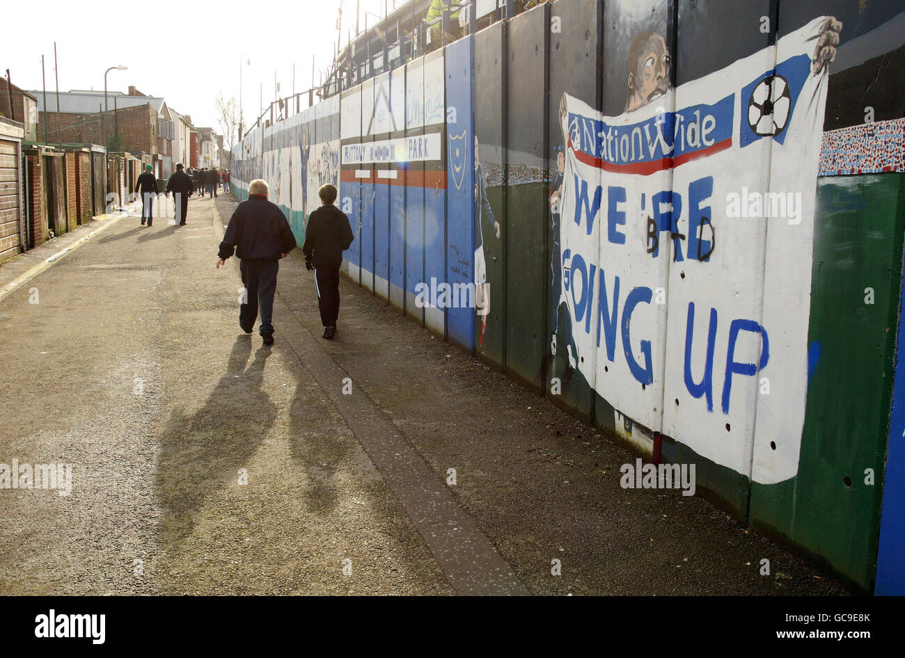 Portsmouth-Fans kommen an einem verblassenden Wandgemälde vorbei, das die Beförderung zur Premier League von Barclay im Jahr 2005 vor dem Stadion feiert, bevor das Spiel der FA Cup Fouth Round im Fratton Park in Portsmouth ausgetragen wird. Stockfoto