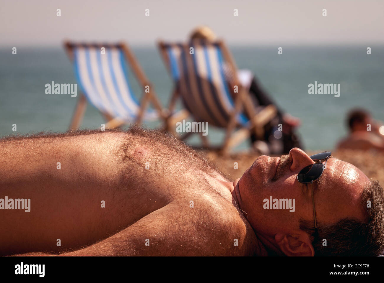 Ein Mann, Sonnenbaden am Strand von Brighton. Stockfoto