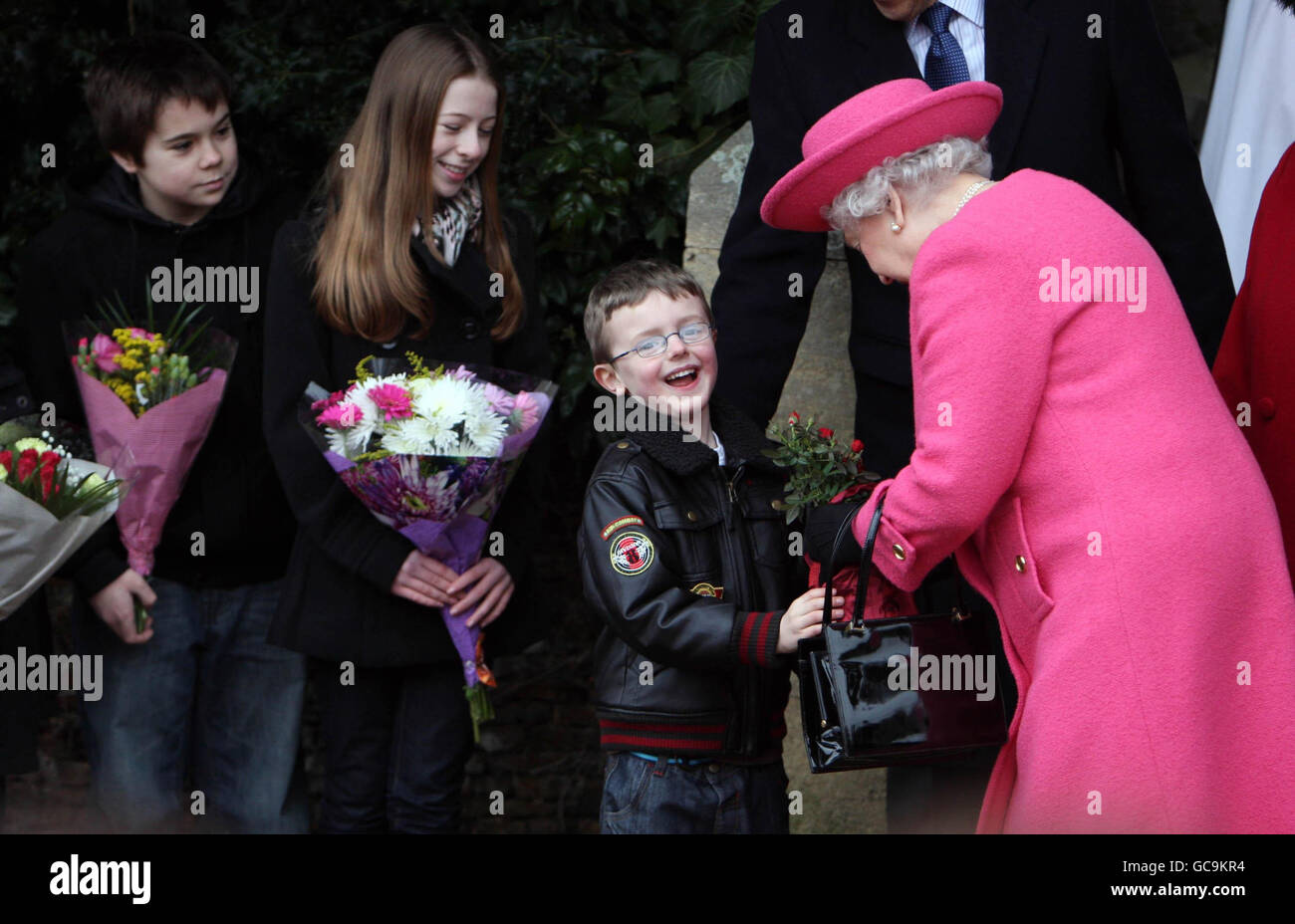 Königin Elizabeth II. Erhält Blumen von Kindern, nachdem sie den Sonntagsgottesdienst in der West Newton Church in der Nähe von Sandringham, Norfolk, besucht hat. Stockfoto