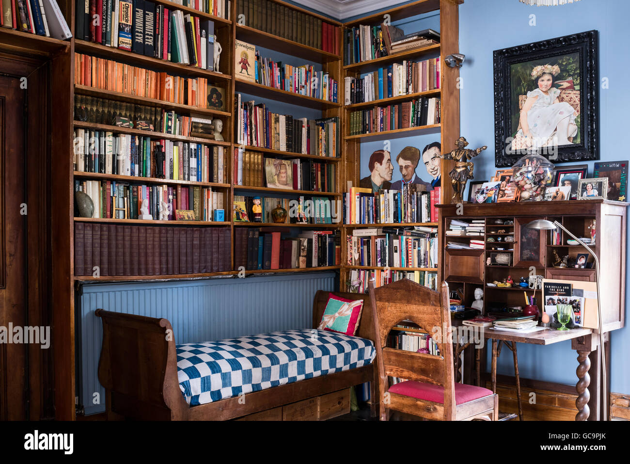 Gerahmte Bilder und Schreibtisch mit Buch-Regal in Nottinghill Studie, London, UK Stockfoto
