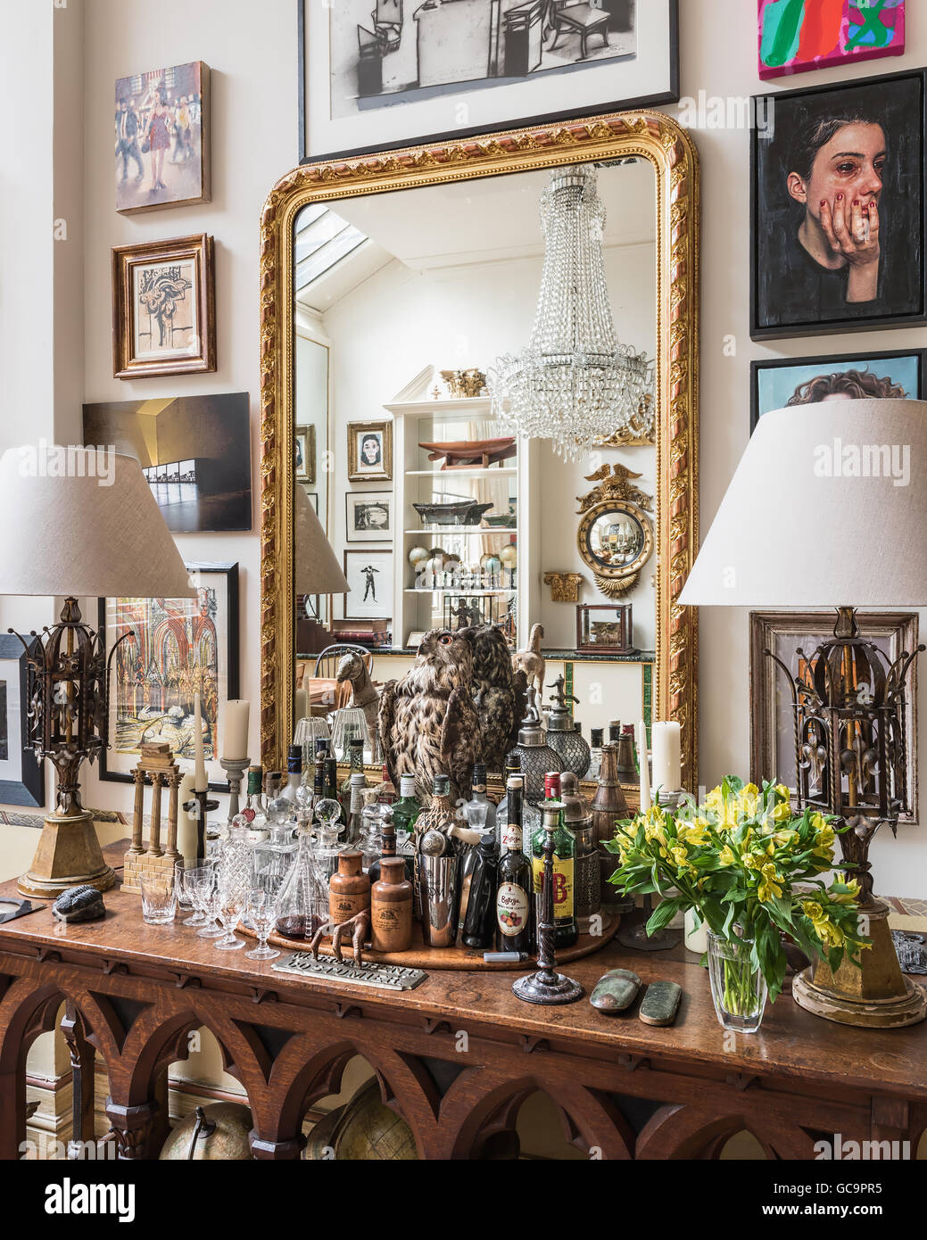 Viktorianischer Mantel Spiegel auf gotischen Eiche Getränke Tisch in London Wohnung voller Kuriositäten, UK Stockfoto