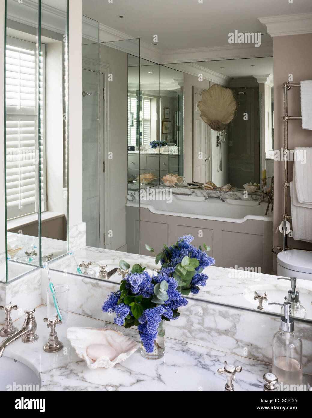 Marmor Waschtisch im Bad mit Spiegelwand Paneelen Stockfoto