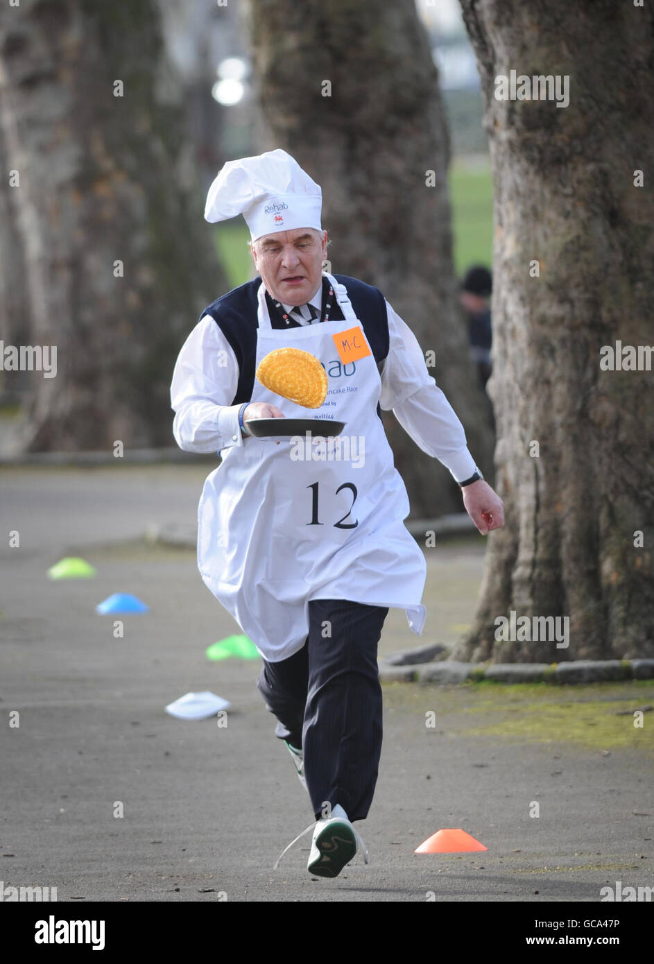 Der Abgeordnete Stephen Pound nimmt am jährlichen Parliamentary Pancake Race in Westminster, London, zusammen mit anderen Abgeordneten, Journalisten und Mitgliedern des Oberhauses Teil, um Geld für die Wohltätigkeitsorganisation Rehab zu sammeln und das Bewusstsein für ihre Arbeit für Menschen mit Behinderungen zu schärfen. Stockfoto