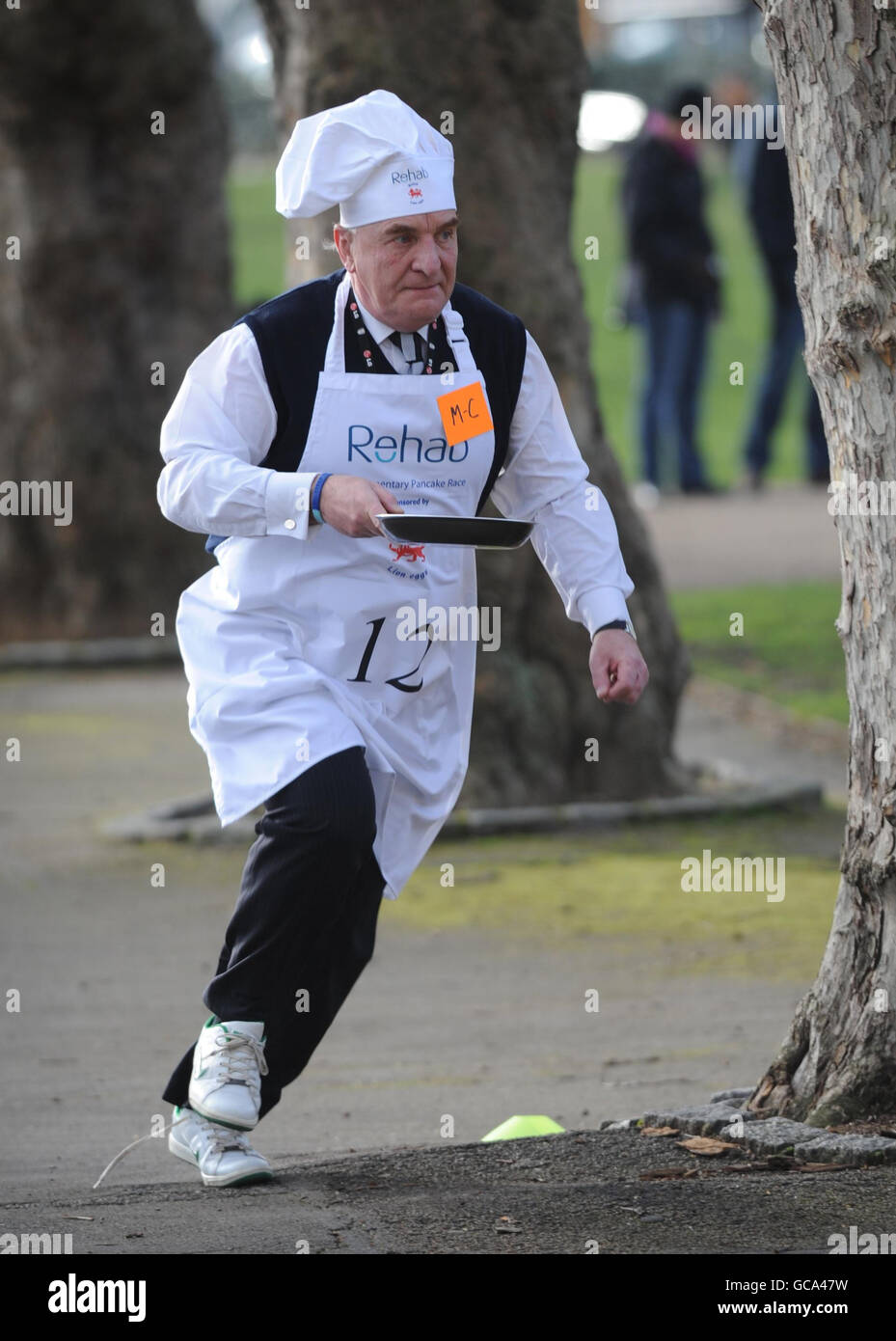 Der Abgeordnete Stephen Pound nimmt am jährlichen Parliamentary Pancake Race in Westminster, London, zusammen mit anderen Abgeordneten, Journalisten und Mitgliedern des Oberhauses Teil, um Geld für die Wohltätigkeitsorganisation Rehab zu sammeln und das Bewusstsein für ihre Arbeit für Menschen mit Behinderungen zu schärfen. Stockfoto