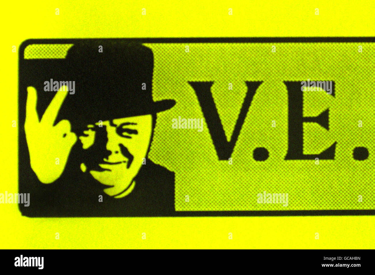WINSTON CHURCHILL GIBT SEIN BERÜHMTES V-ZEICHEN FALSCH HERUM, WIE ES AUF PLAKATEN IN DER STADT BOURTON-ON-THE-WATER ZU SEHEN IST. DIE PLAKATE, DIE DIE SIEGESEREIGNISSE IN DER STADT BEKANNT MACHEN, WURDEN VOM COTSWOLD DISTRICT COUNCIL GEDRUCKT, DER DIE COMPUTERTECHNOLOGIE BESCHULDIGT. Stockfoto
