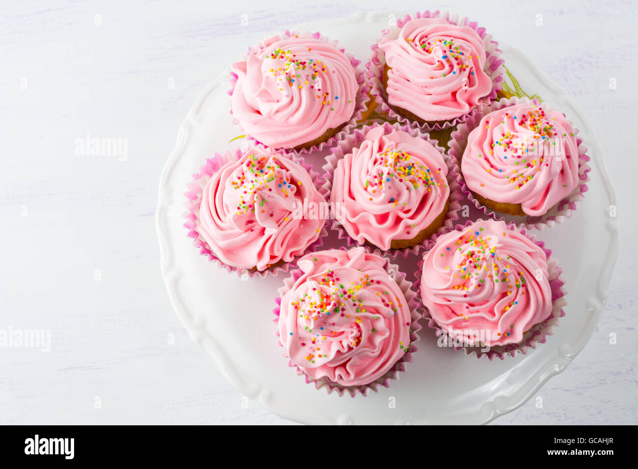 Rosa Muffins auf Kuchen stehen Draufsicht. Geburtstag Kuchen mit Schlagsahne. Hausgemachte Muffins serviert für Party. Geburtstag Hinterg Stockfoto