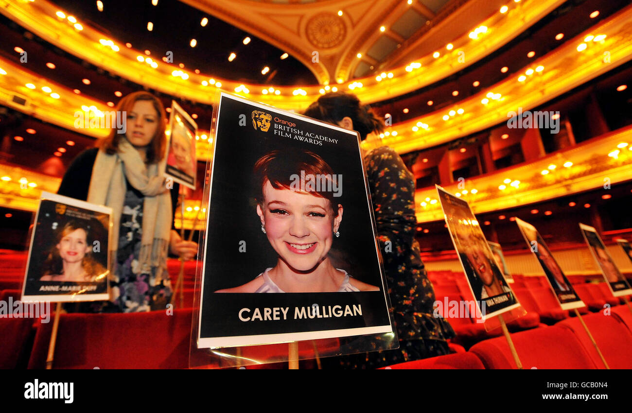 Das Veranstaltungspersonal platziert Fotos von Filmstars, die an der BAFTA (British Academy of Film and Television Arts)-Preisverleihung dieses Wochenendes im Auditorium des Royal Opera House im Zentrum von London teilnehmen. Stockfoto