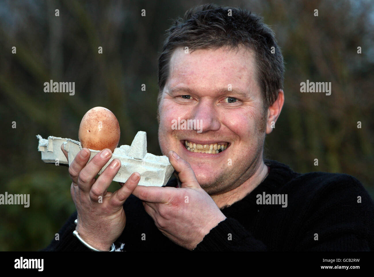 Riesiges Ei. Mark Cornish aus Ipswich, Suffolk, posiert mit einem übergroßen Ei, das von seiner Henne Matilda gelegt wird. Stockfoto